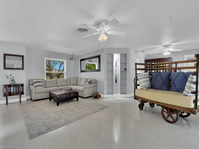 Living room with a textured ceiling and ceiling fan
