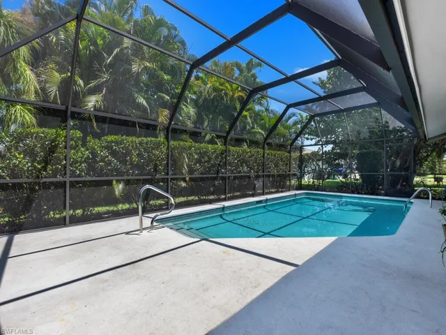 View of swimming pool with glass enclosure and a patio area