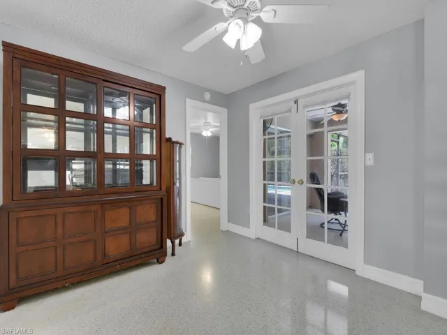 Unfurnished room featuring ceiling fan, french doors, and a textured ceiling