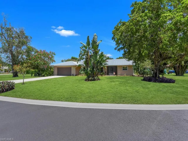 Single story home with a garage and a front lawn
