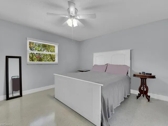 Bedroom with ceiling fan and a textured ceiling