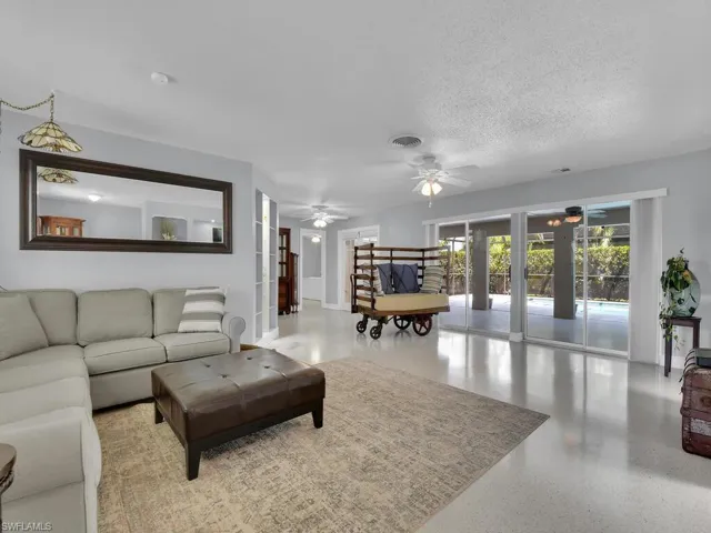 Living room with ceiling fan and a textured ceiling