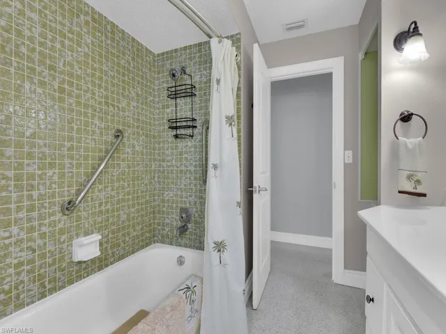 Bathroom featuring shower / bathtub combination with curtain and vanity