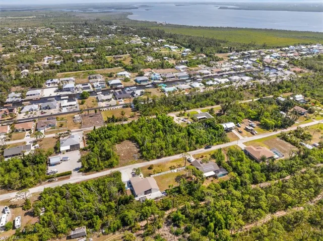 Aerial view of property's location with a nearby body of water and nearby suburban area