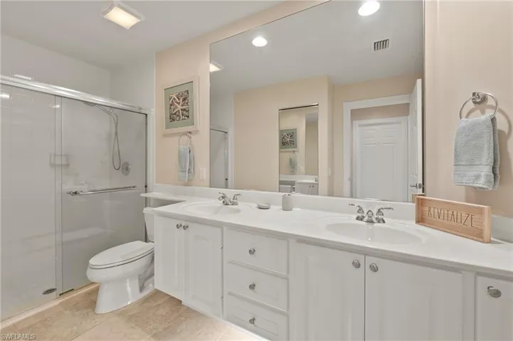 15416 Almaco Cir Bonita Springs FL 34135 - Owners bath with seamless glass doors, linen closet, and under vanity lighting