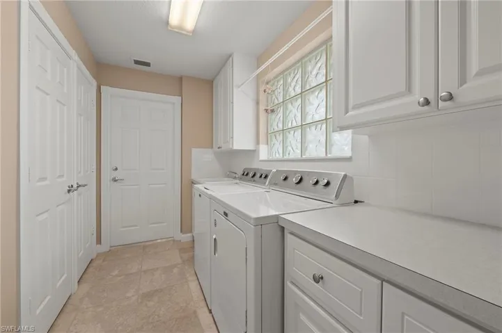 15416 Almaco Cir Bonita Springs FL 34135 - Laundry room has a utility sink and lots of cabinets for additional storage.