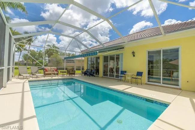 View of swimming pool with a patio area, glass enclosure, and an outdoor hangout area