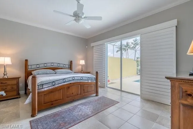 Tiled bedroom with ceiling fan, access to exterior, and ornamental molding