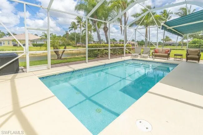 View of pool featuring glass enclosure and a patio area