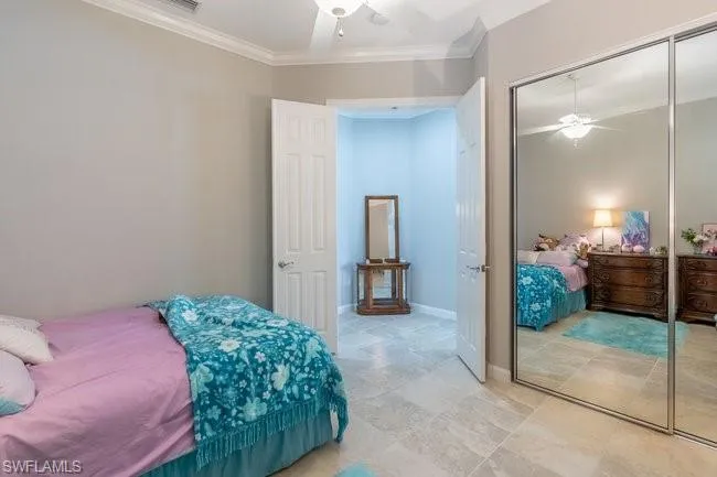 Bedroom with a closet, crown molding, and ceiling fan
