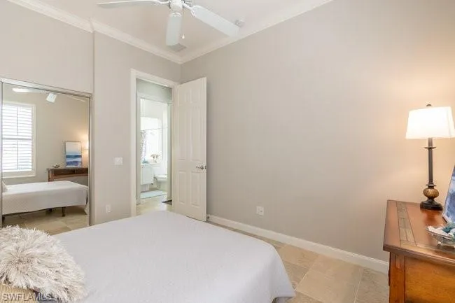 Tiled bedroom featuring ceiling fan and ornamental molding