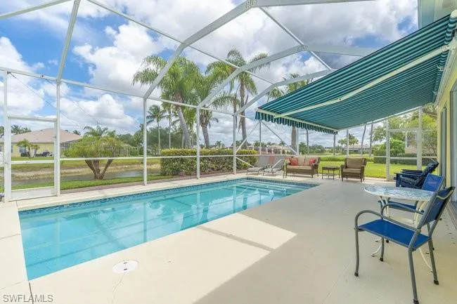 View of swimming pool featuring a lanai, an outdoor living space, and a patio