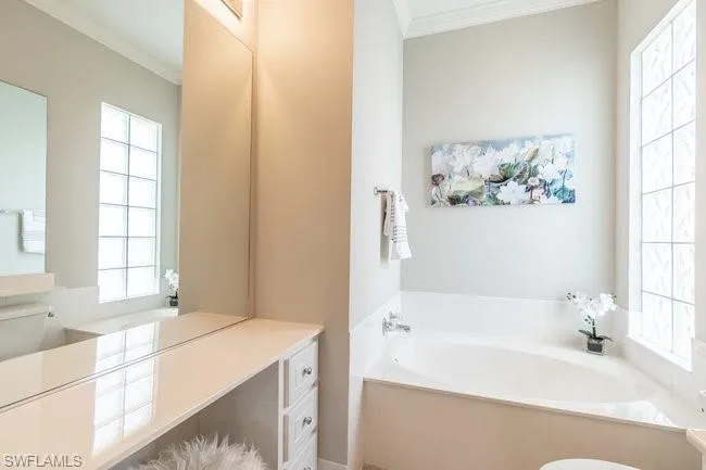 Bathroom with a bath and crown molding