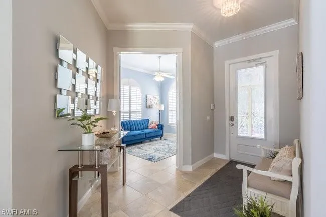 Tiled foyer featuring a wealth of natural light, ornamental molding, and ceiling fan