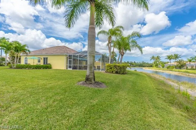 View of yard with a lanai and a water view