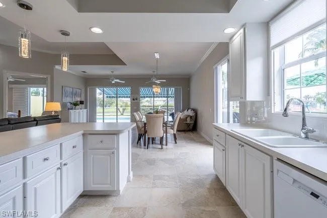 Kitchen featuring white cabinetry, dishwasher, plenty of natural light, and sink