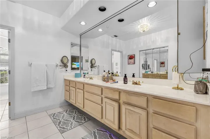 Bathroom with double vanity, recessed lighting, and light tile patterned flooring