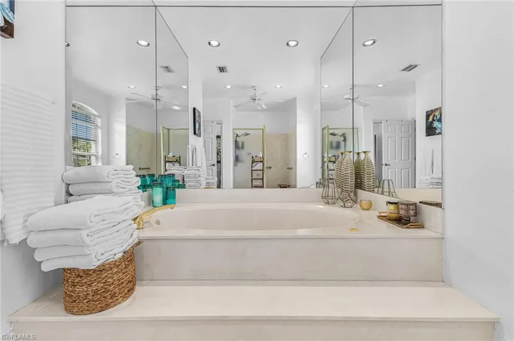 Full bathroom with a shower stall, recessed lighting, and a garden tub
