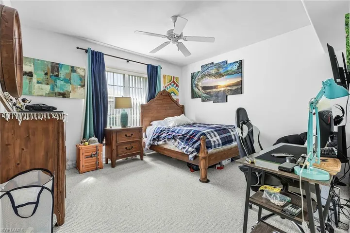 Carpeted bedroom featuring ceiling fan
