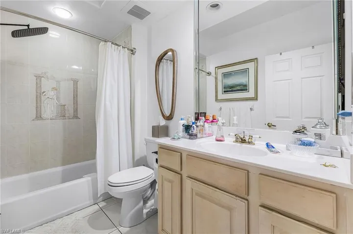 Full bath featuring vanity, light tile patterned floors, and shower / bath combination with curtain