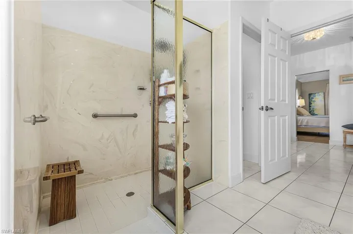 Full bath featuring ensuite bath, a marble finish shower, and light tile patterned floors