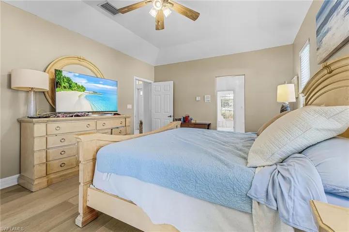 Bedroom featuring a ceiling fan, light wood finished floors, and vaulted ceiling