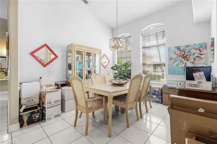 Dining area featuring a high ceiling, a chandelier, and light tile patterned floors