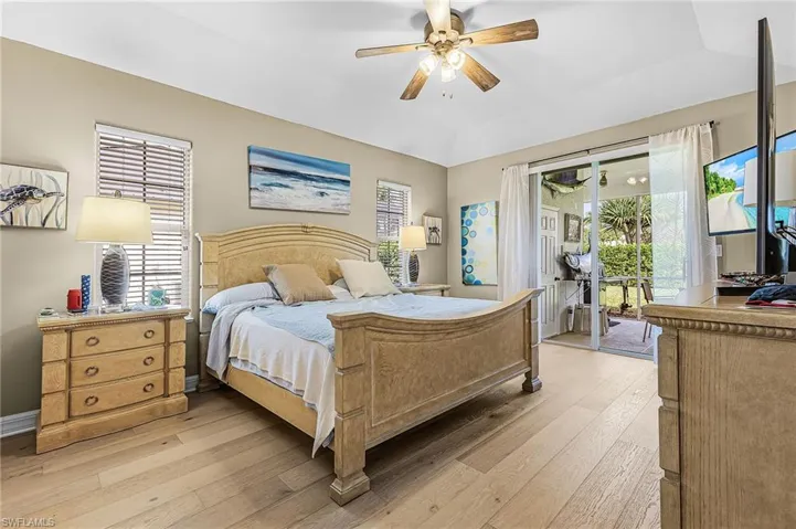 Bedroom with access to outside, light wood-type flooring, a ceiling fan, and vaulted ceiling