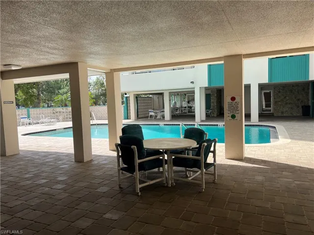 Community pool featuring fence and a patio