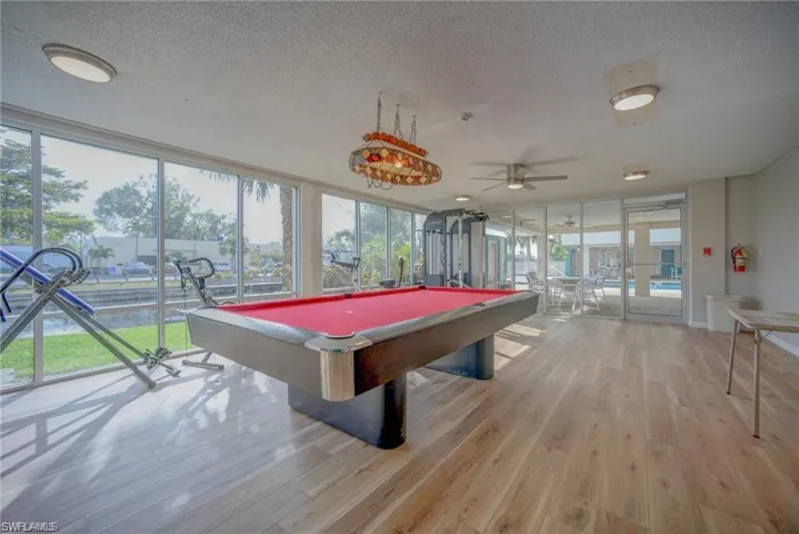 Game room featuring pool table, light wood-type flooring, and a wealth of natural light
