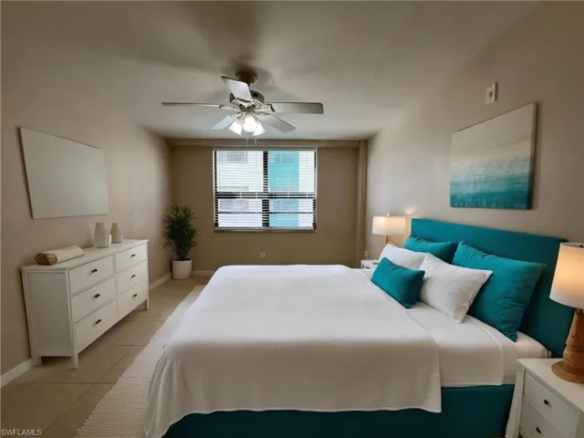 Bedroom with baseboards, ceiling fan, and light tile patterned floors