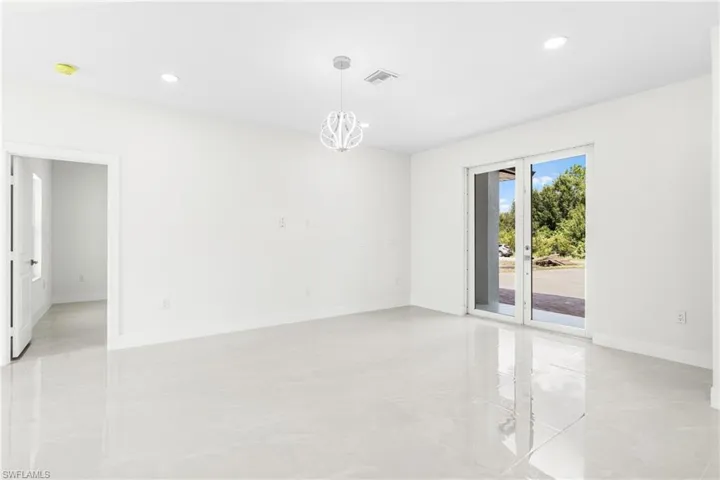 Unfurnished room featuring a notable chandelier
