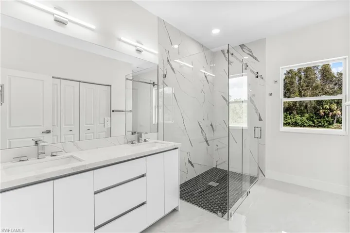 Bathroom with vanity and a shower with door