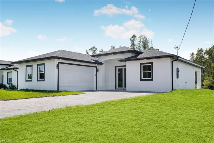 View of front of property with a garage and a front yard