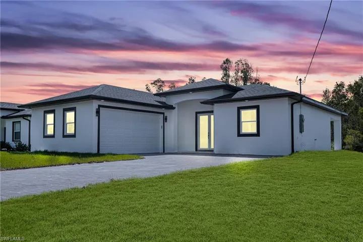 View of front of home featuring a garage and a lawn