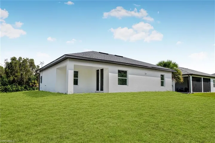 Back of house with a lawn and a sunroom