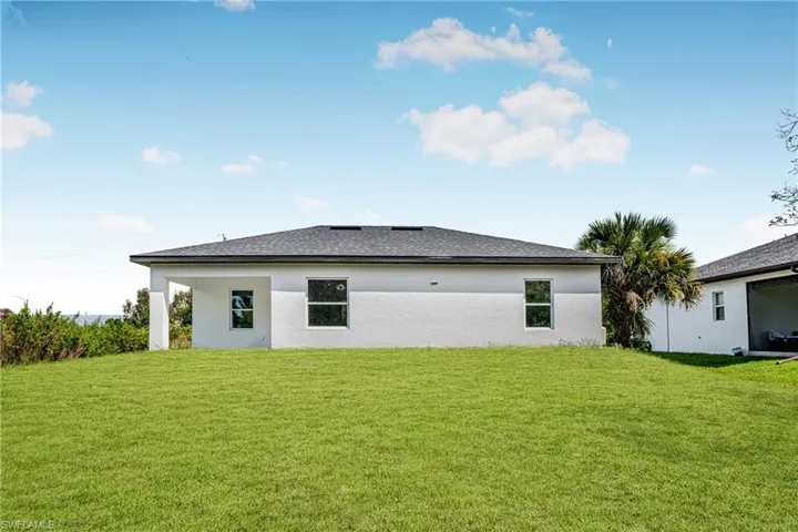 Back of house featuring a yard