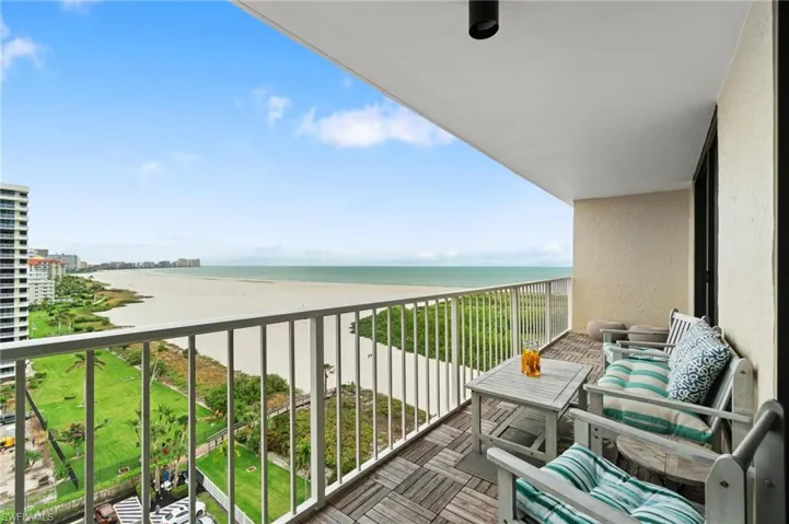 Balcony featuring view of water and beach