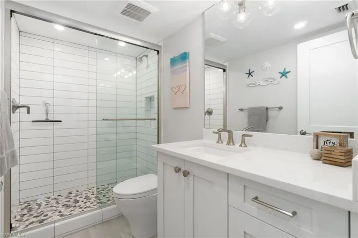 Full bath with vanity, a shower stall, and recessed lighting