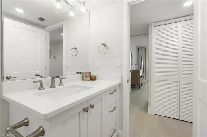 Bathroom with recessed lighting, vanity, and a closet