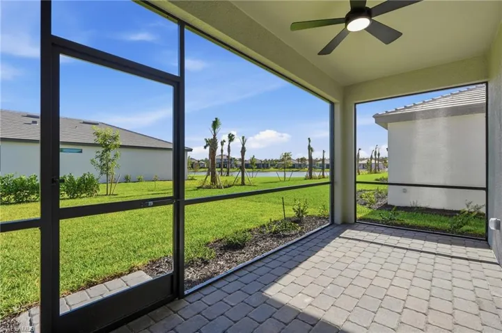 Screened-in lanai featuring paver flooring, a ceiling fan with integrated lighting, and an expansive frame enclosing outdoor space