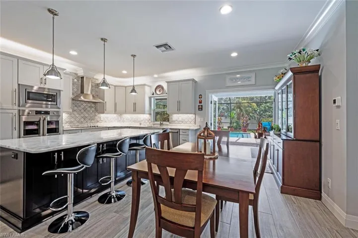 Dining space with light wood finished floors, recessed lighting, and crown molding