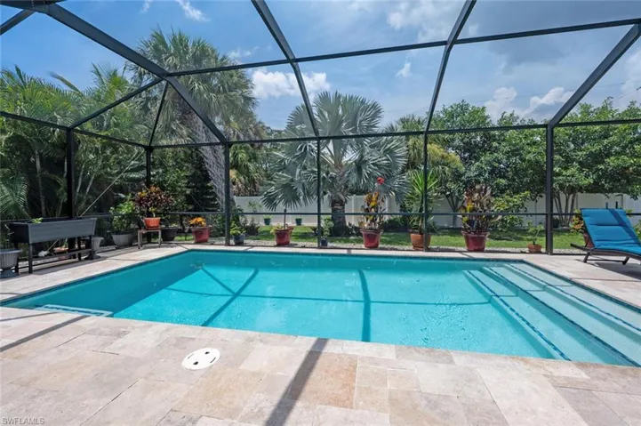 Outdoor pool featuring a patio area and glass enclosure