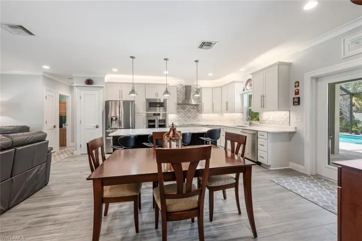 Dining space featuring light wood-style flooring, crown molding, and recessed lighting