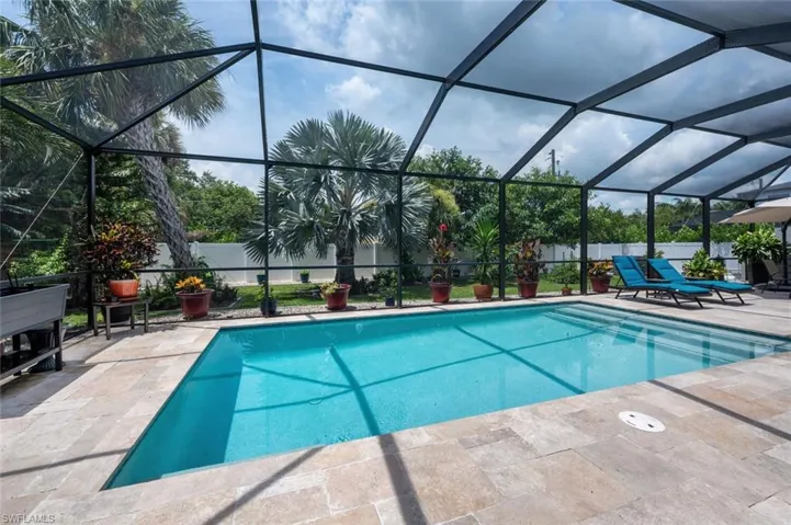 View of pool with a patio area, a fenced backyard, and a lanai