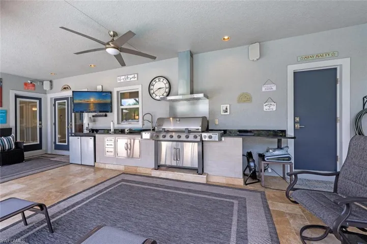 View of patio with exterior kitchen and a ceiling fan