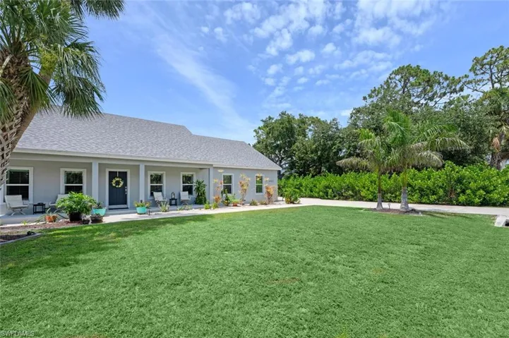 View of front of property featuring a front lawn and roof with shingles