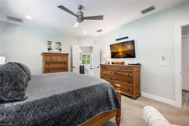 Bedroom featuring light colored carpet, a ceiling fan, and recessed lighting