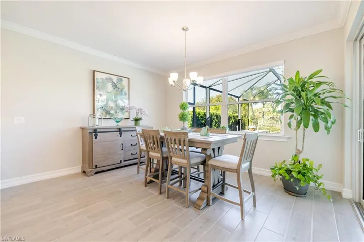 Dining room featuring crown molding, wood tiled floors, and a chandelier