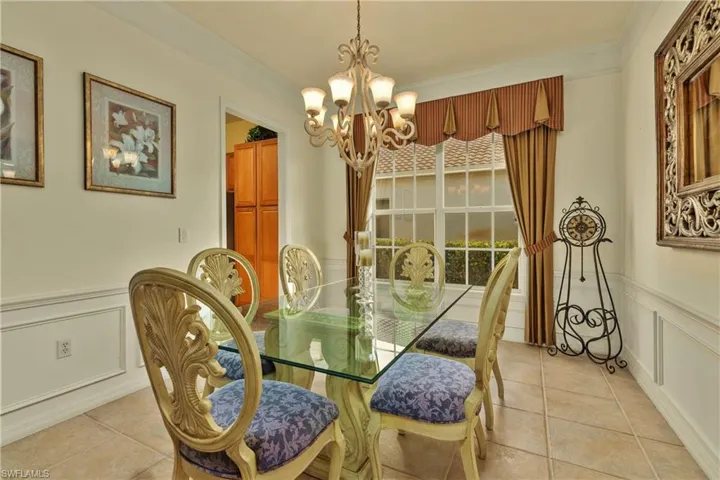 Tiled dining area with a chandelier and ornamental molding